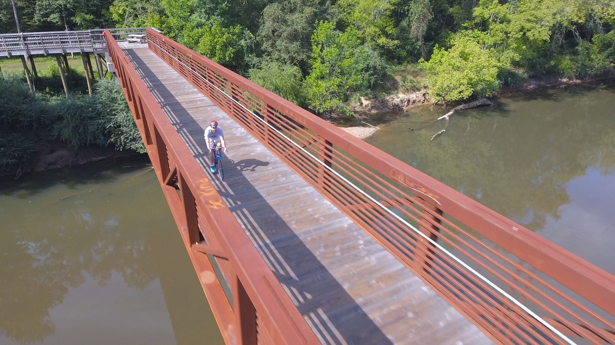 Biking across pedestrian bridge of greenway_1