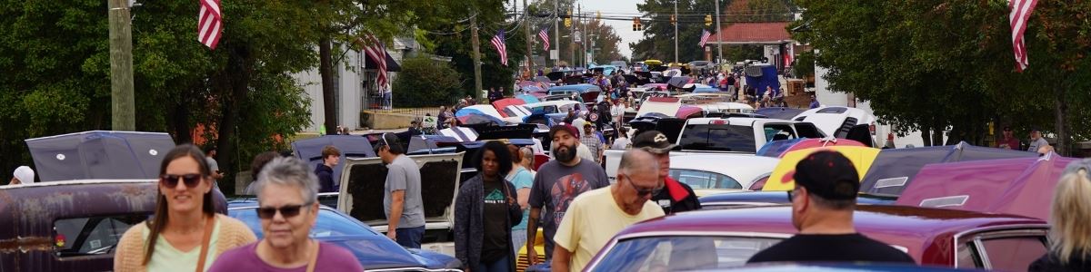 People explore street and look at cars in car show at Clayton Harvest Festival